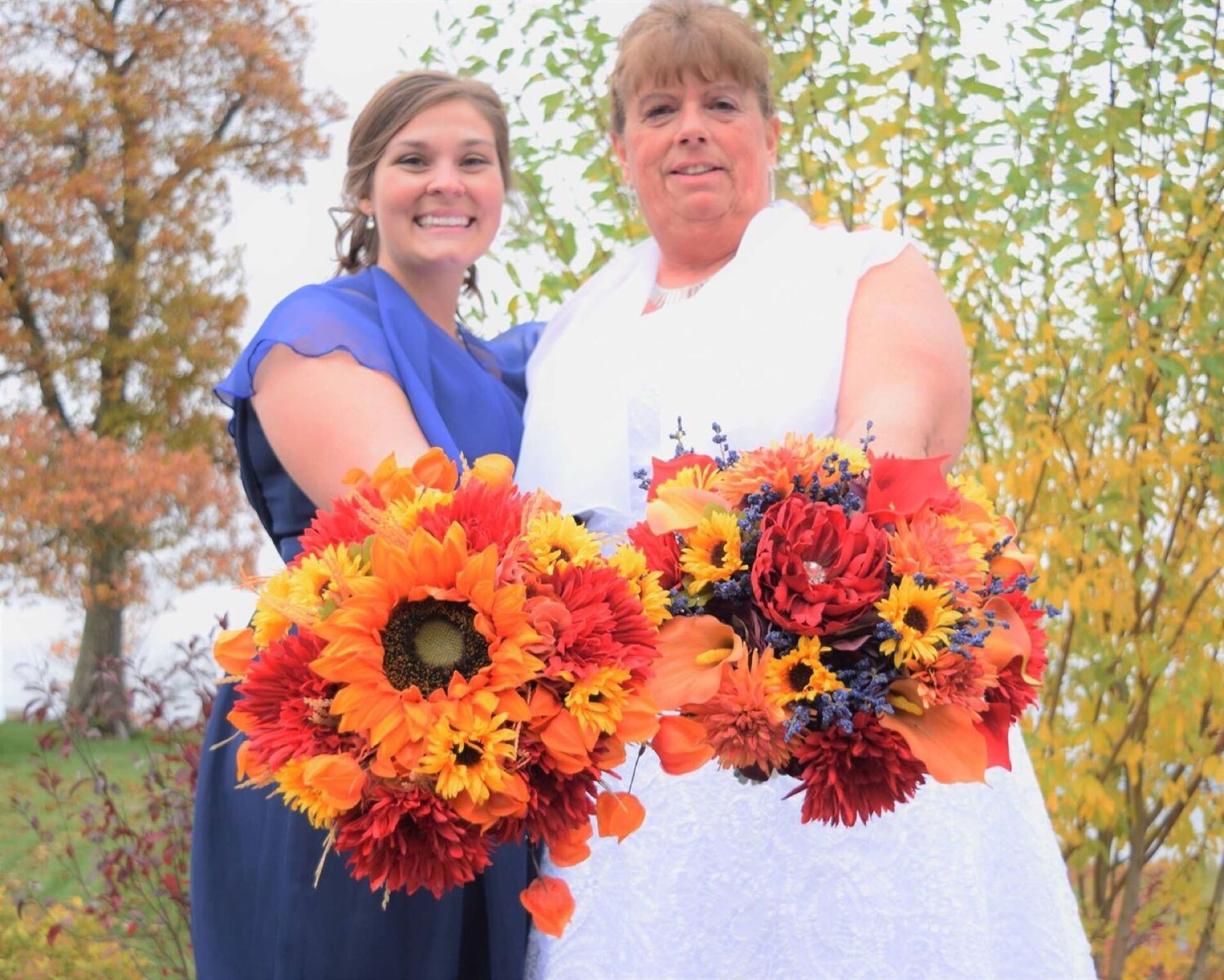 Bride and bridesmaid with sunflower and dahlia bouquets