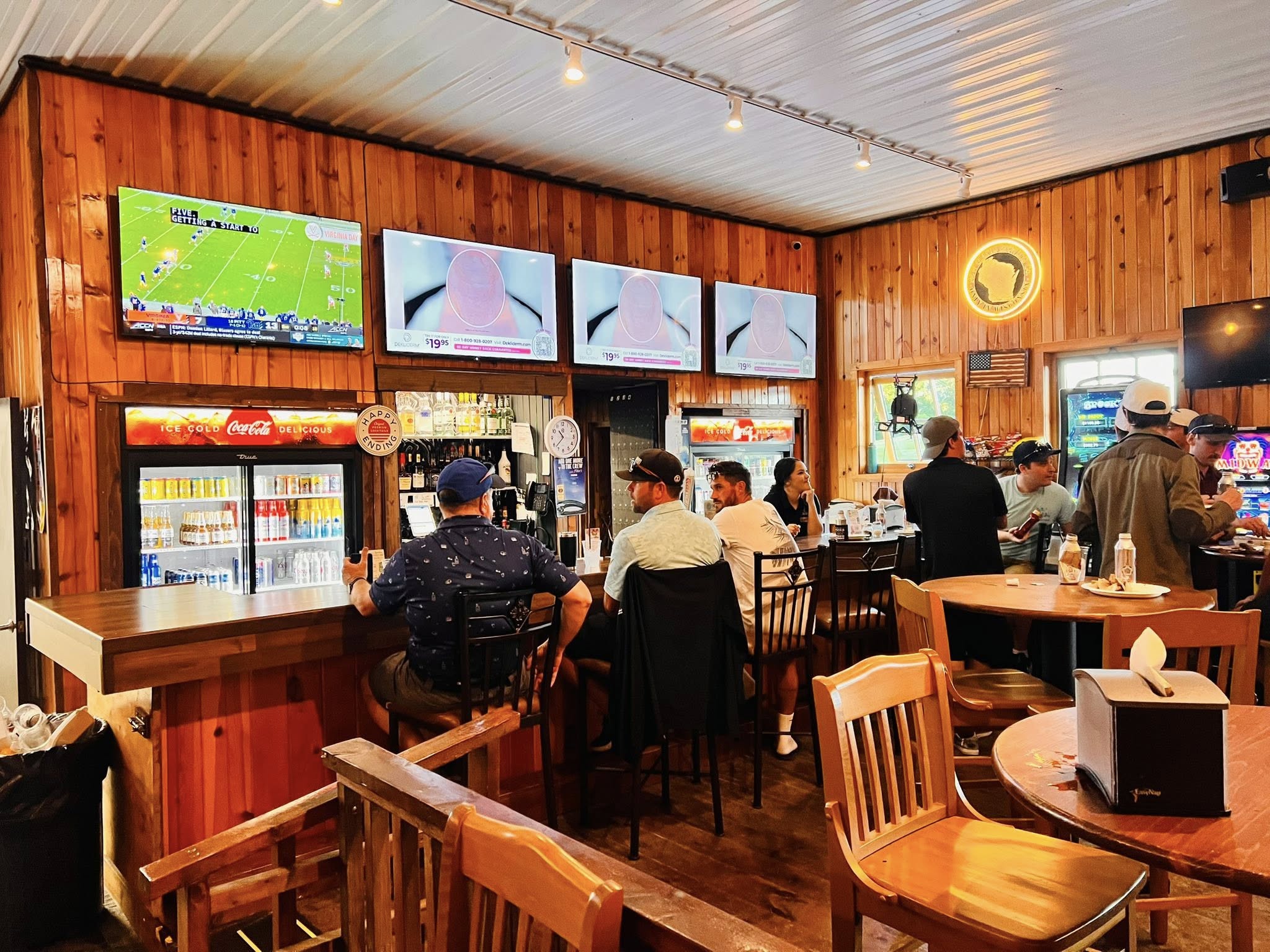 Inside Dye Hards: wood-panelled bar with TVs and guests at the counter