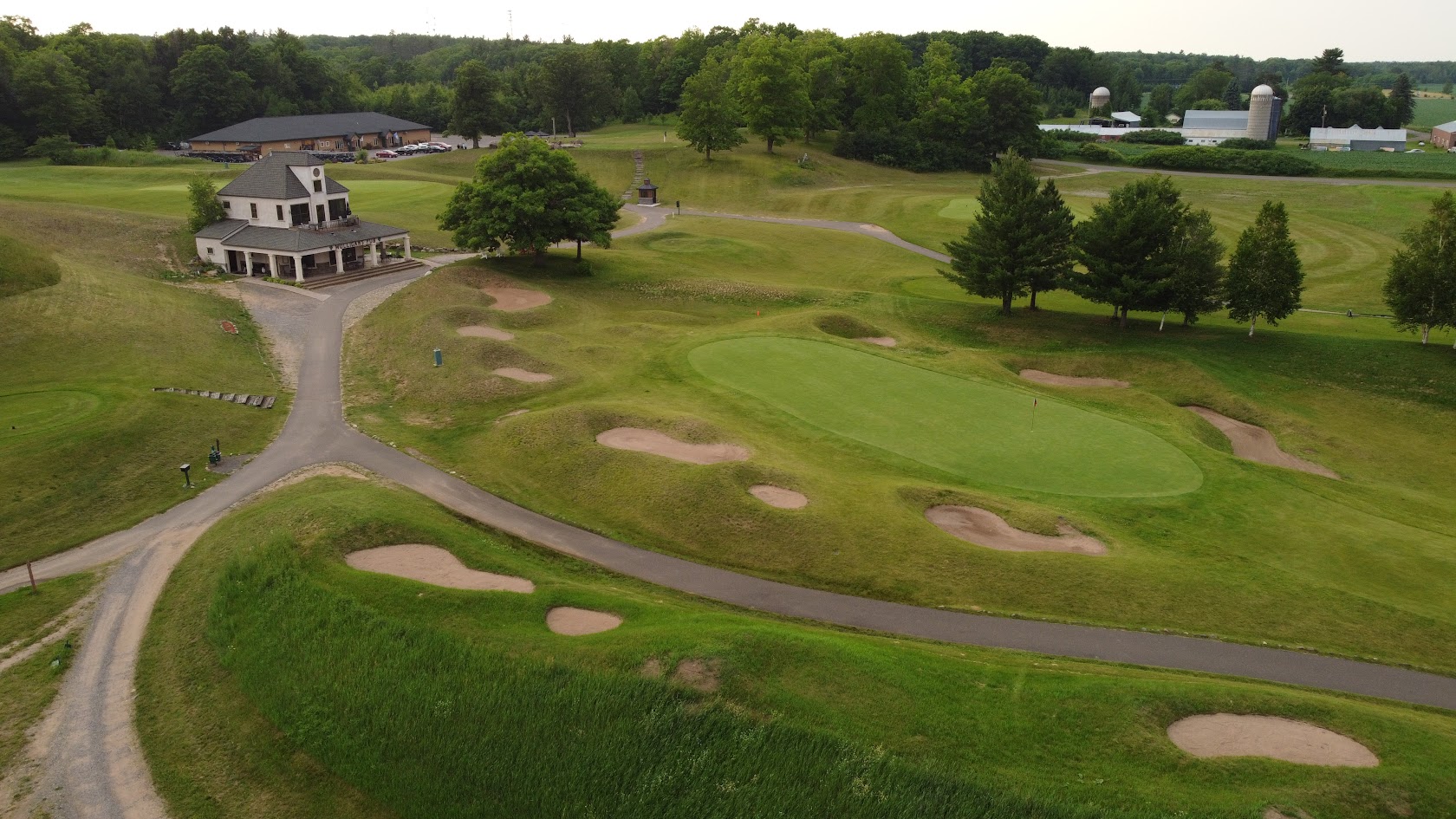 Aerial view of the clubhouse above a green and bunkers